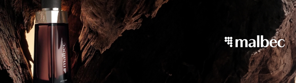 Frasco de perfume Malbec posicionado dentro do tronco de uma árvore.