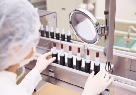 Imagem de pesquisadora em laboratório analisando vários batons.