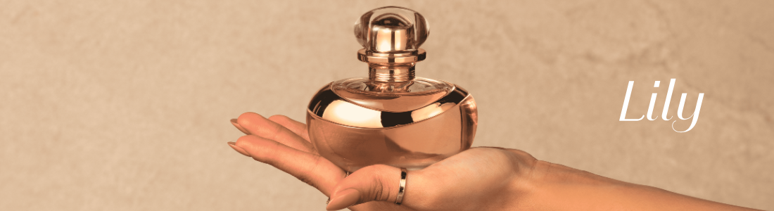 Mão feminina segurando perfume dourado Lily em fundo bege texturizado.