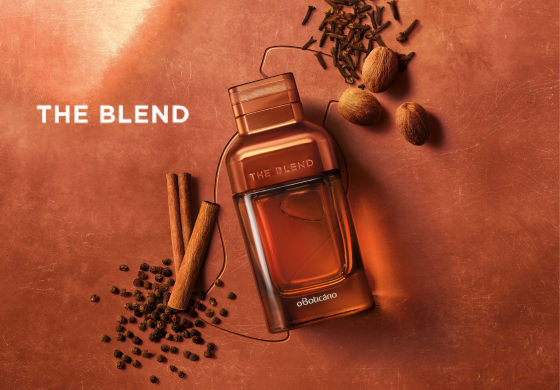 Frasco de perfume The Blend cercado por especiarias em fundo de cobre envelhecido.