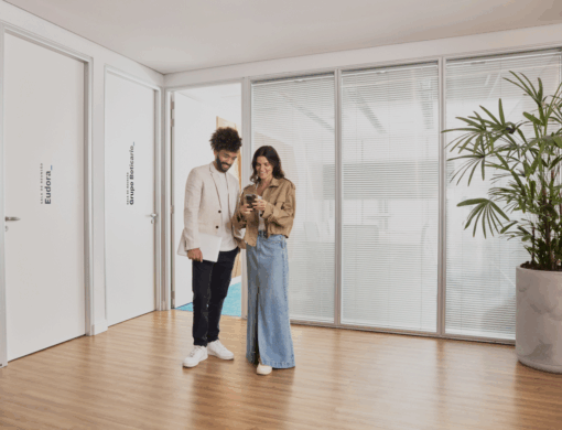 homem e mulher em sala do Grupo Boticário olhando para tela de celular.