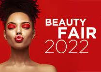 Imagem Beauty Fair 2022. Na direita temos uma mulher, negra com cabelos crespos preso e com maquiagem vermelha. Ao lado direito está escrito Beauty Fair 2022