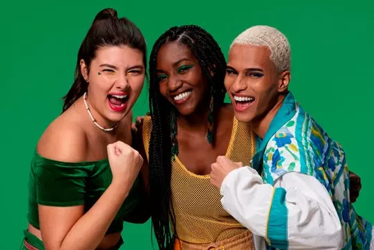 http://Campanha%20Quem%20Disse,%20Berenice?%20e%20Guaraná%20Antarctica%20se%20juntam%20para%20torcer%20pelo%20Brasil%20com%20coleção%20inspirada%20nas%20cores%20do%20país%20-%20na%20frente%20do%20fundo%20verde%20temos%20três%20torcedores%20brasileiros,%20da%20esquerda%20para%20direita%20tem%20uma%20mulher%20branca%20com%20rabo%20de%20cavalo%20preso,%20acessório%20branco%20no%20pescoço,%20veste%20um%20cropped%20verde%20da%20cor%20da%20bandeira%20e%20está%20com%20punho%20cerrado%20e%20expressão%20de%20grito%20e%20energia.%20Ao%20lado%20dela%20tem%20uma%20mulher%20negra%20com%20tranças%20pretas%20longas,%20ela%20está%20sorrindo%20e%20veste%20uma%20regata%20cor%20de%20amarelo%20com%20furinhos.%20Ao%20lado%20têm%20um%20homem%20negro.%20Ele%20tem%20cabelos%20bem%20curtos%20e%20cor%20branca.%20Veste%20uma%20blusa%20com%20magas%20longas%20acor%20azul%20claro%20e%20branco.%20Também%20está%20com%20o%20punho%20cerrado%20e%20expressão%20de%20grito%20e%20energia