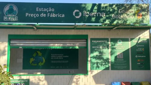 Estação de coleta de vidro e papel "Preço de Fábrica", imagem tirada da frente da estação de coleta à luz do dia