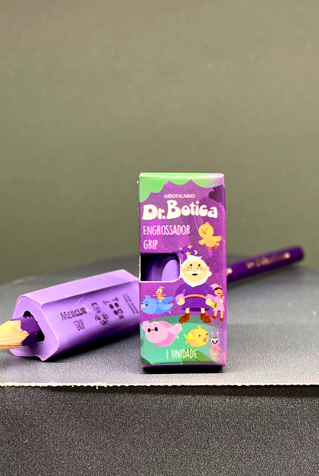 Embalagem Dr. Botica "Engrossador Grip" e lápis com apontador roxo em fundo cinza.